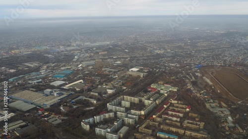 Aerial view of Almaty city suburbs and hippodrome track during daytime under cloudy sky, slow motion aerial panorama.