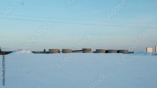 Konstfotografi The scene depicts a serene winter landscape blanketed in freshly fallen snow, where expansive concrete structures rise prominently near a secluded area