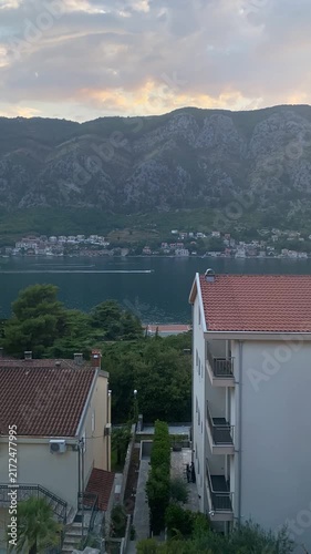 High-angle view timelapse of Bay of Kotor in Montenegro and steep mountains at sunset with boats passing by