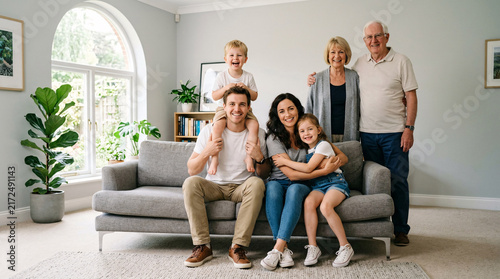 Happy multigenerational family posing together in a bright living room