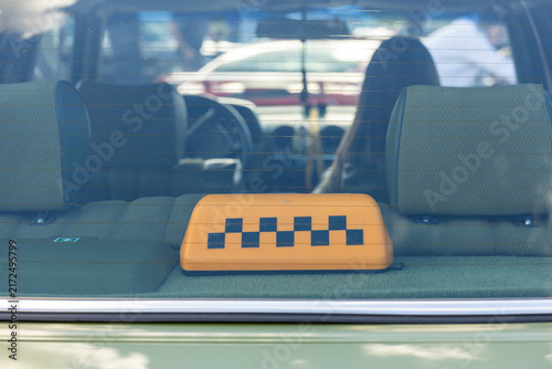 Canvastavla Taxi sign on rear shelf of vintage car seen through back window