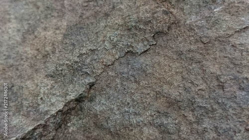 Fotografie Natural dark gray and brown rugged rock surface with prominent cracked layers texture background