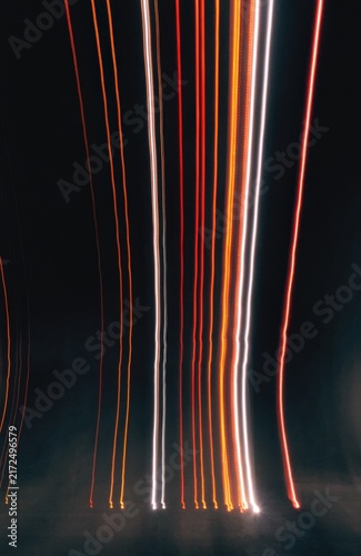 Abstract light trails of red, orange, and white streaks against a dark background