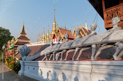 Canvas Print Sculpted balustrade with serpent mechanism and golden temple chedi spires at Wat Phra That Suthon Mongkhon Khiri in Phrae, Thailand