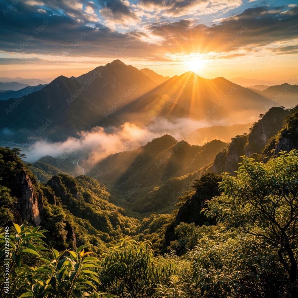 Obraz premium Golden sun shines over high mountain peaks at sunrise. Mist floats in valley between green hills, forest. Beautiful landscape view with orange sky, clouds, light rays. Scenic nature panorama during