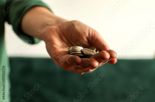 Foto Close-up of a person's outstretched hand holding a few coins against a blurred background