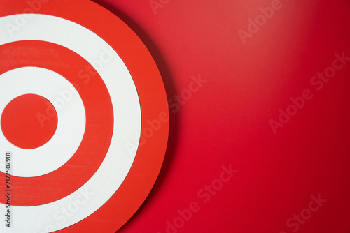 Target circle on a red background. Goal and planning concept. Marketing and targeting help define priorities, reach audiences and measure campaign results.