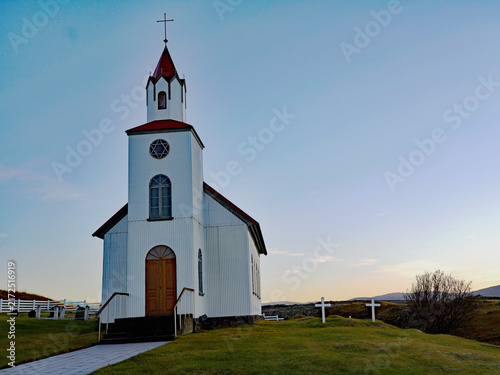 Quadro su tela A traditional white church with a red spire and adjacent cemetery crosses stands