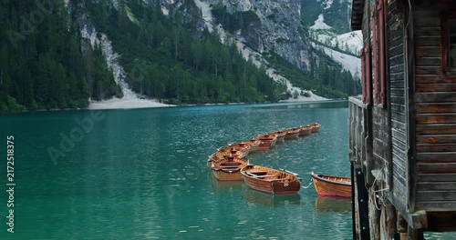 Wooden rowboats floating on braies lake in the dolomites