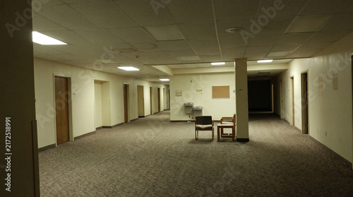 Empty eerie office hallway evoking a liminal space atmosphere