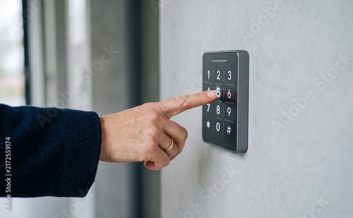 Fototapeta kuchenna Person entering security code on electronic keypad access control system