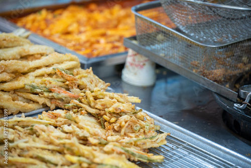 фотографія Close up view of delicious crispy deep fried vegetable fritters displayed at a local traditional market stall