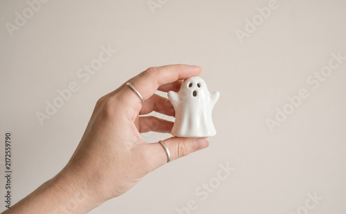 Fototapeta kuchenna A person holding a small white ceramic ghost figurine in hand, minimalist Halloween decor and spooky spooky concept