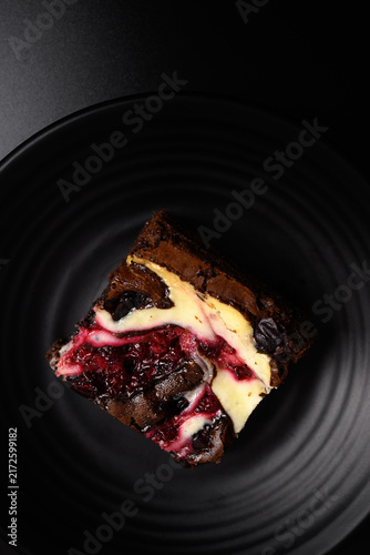 Close-up of delicious homemade cranberry cream cheese brownies on a dark background