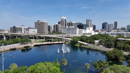Flying forward towards the Lake Lucerne fountain and the downtown Orlando skyline in Orange County, Orlando, Florida, USA.