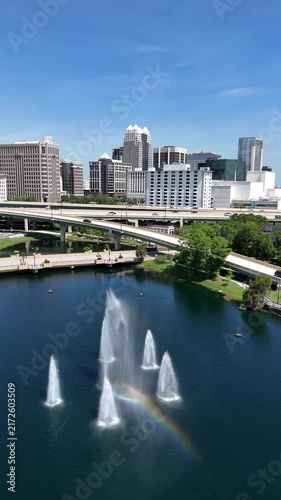 Rainbow in the Lake Lucerne fountain with the downtown Orlando skyline in Orange County, Orlando, Florida, USA.