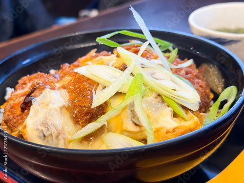 Fototapeta 卵で閉じたアツアツのトンカツをご飯の上に乗せた和食のカツ丼。