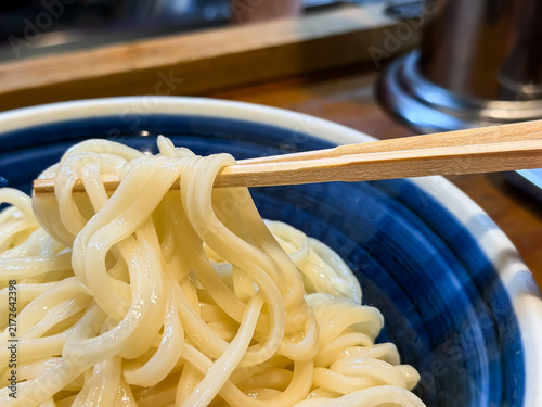 Fototapeta 冷たいうどんの麺を箸で持ち上げているクローズアップ。