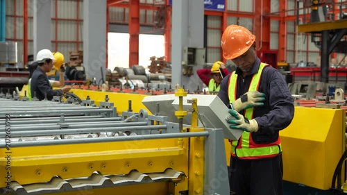 Engineers and staff are inspecting the assembly line system in a metal sheet and metal roofing manufacturing plant. (VDO 4K)	