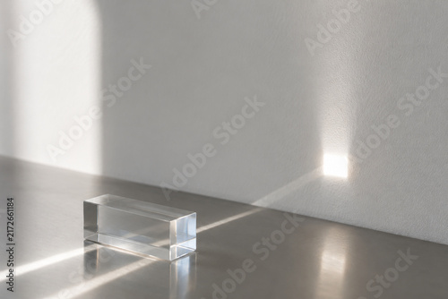 Sunbeam passing through clear acrylic block onto white wall, light transmittance concept
