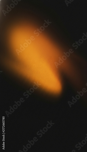 An abstract blurred image featuring a swirling luminous orange form against a dark background high-quality
