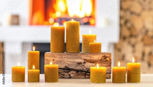 Set of beeswax honeycomb candles casting a warm glow near a fireplace