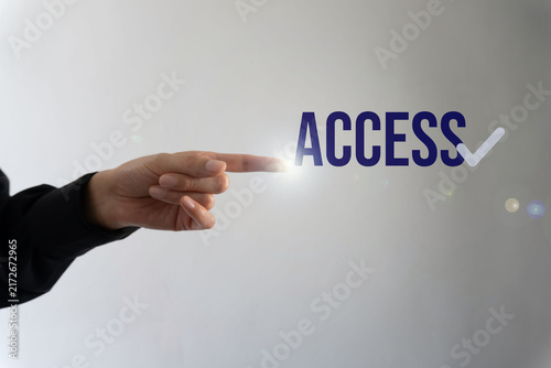 Fotografie Human hand gestures toward text 'ACCESS', implying authorization or entry