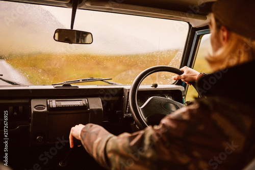 Foto Woman driving off road vehicle on rainy rural journey