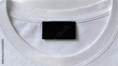 Blank black clothing label on white t-shirt collar, mockup template for brand logo, sewing thread details, empty textile branding tag, white cotton fabric texture background