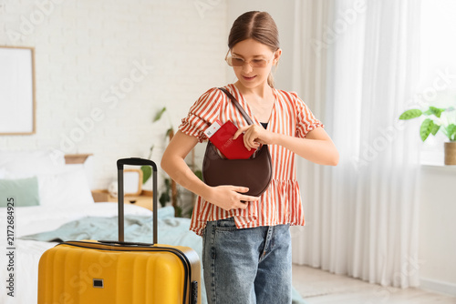 Travel preparation and vacation planning, young woman putting passport and bo...