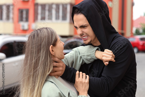 Принти на полотні Domestic violence and abuse, aggressive man choking a woman in a public street c