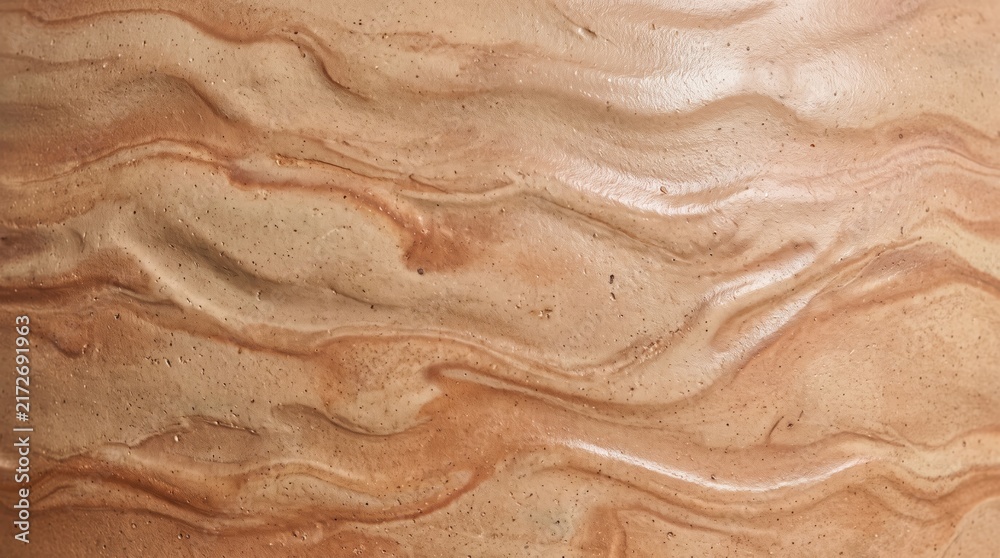 Obraz premium Close-up of a beige and brown bio-ceramic surface featuring wavy, flowing organic textures with subtle speckled granular details and smooth, undulating ridges across the entire frame