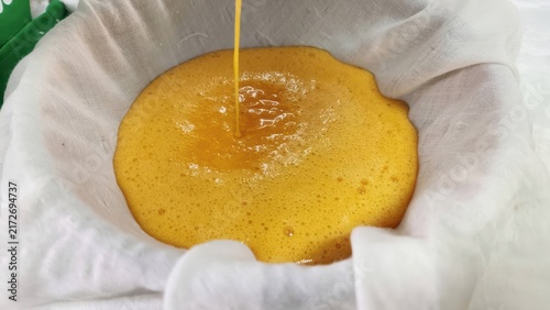 Quadro su tela Straining Egg Yolk Mixture through White Cheesecloth for Thai Dessert