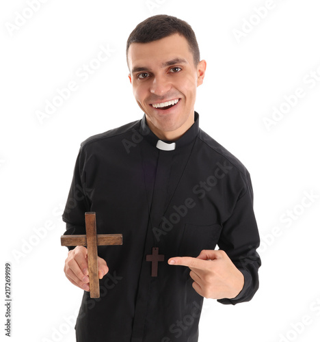 Obraz na płótnie Young priest pointing at cross on white background