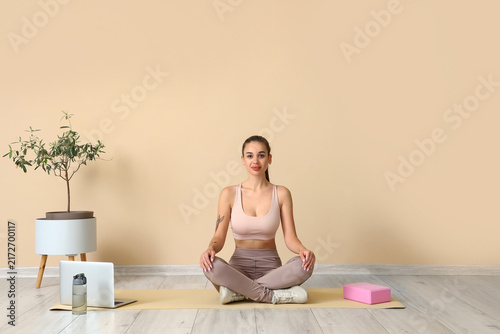 Sporty young woman training at home