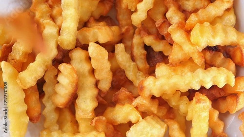 Enjoying crispy crinkle cut fries at a food stall