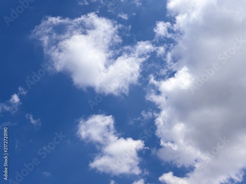 Beautiful bright blue sky with fluffy white cumulus clouds on a sunny day. Natural atmospheric landscape scenery background with large copy space for environmental concept and weather design template.