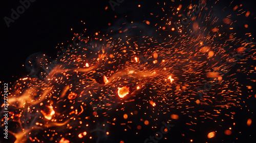 abstract fire ember background, intense glowing orange and red fire embers blowing dynamically through the wind