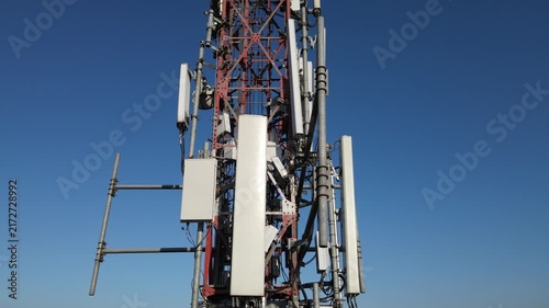 Aerial Footage of Several Radio Masts and Antennas Mounted on a Large Telecommunication Tower During Morning Against a Clear Blue Sky in Karanglewas, Indonesia. 