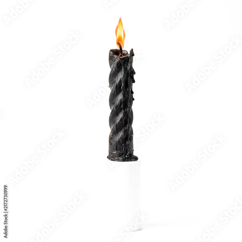 Black twisted candle with glowing flame isolated.