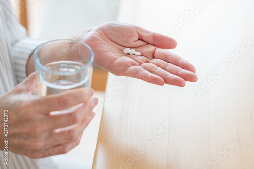 薬を飲む女性の手元　サプリを飲む