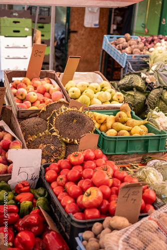 Fruits and vegetables at the benches of a grocery store of a local market. Vertical photo.