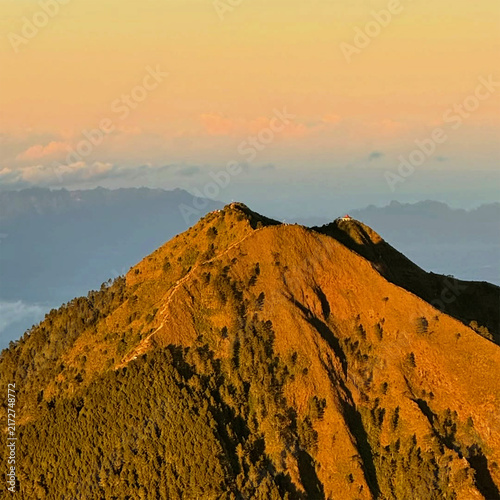 Cuadro en lienzo Majestic mountain peak illuminated by golden sunrise light with green forest tre
