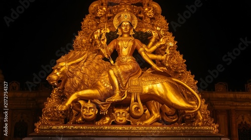 Majestic golden religious sculpture of deity triumphant over mythical creatures in elaborate temple setting with surrounded detailed carvings mythical elements grand