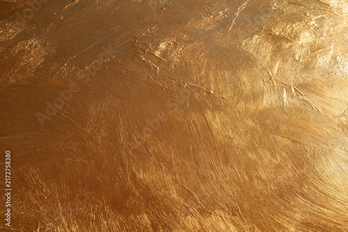 Abstract gold paint texture with visible brush strokes