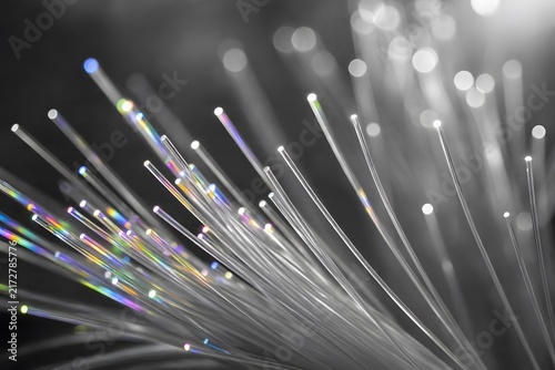 Glowing fiber optic strands close up abstract light trails network connection technology background