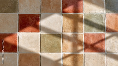 Terracotta floor tiles with geometric light patterns
