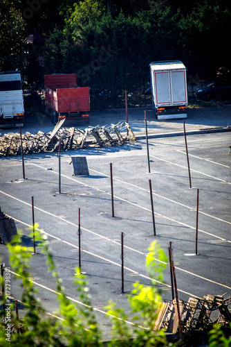 An open space in Istanbul where a market is set up. Wooden poles planted in the ground and their shadows. Top view, above, up. No people, nobody. Vertical photo.