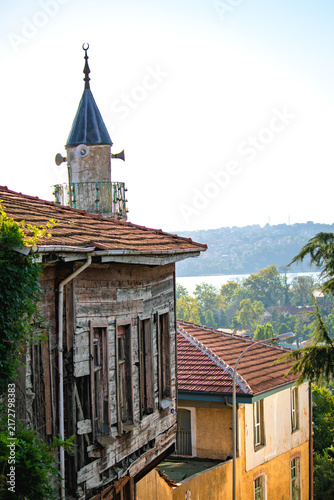 Historic streets in Beykoz, Istanbul. A wooden mansion, a mosque, and a minaret. Neighborhood culture. No people, nobody. Vertical photo. 