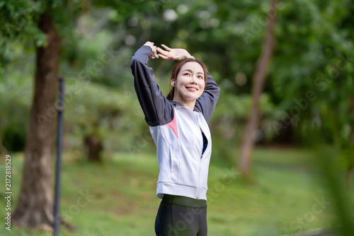 Obraz na plátne Asian woman stretching before a workout in a public park to maintain a healthy lifestyle